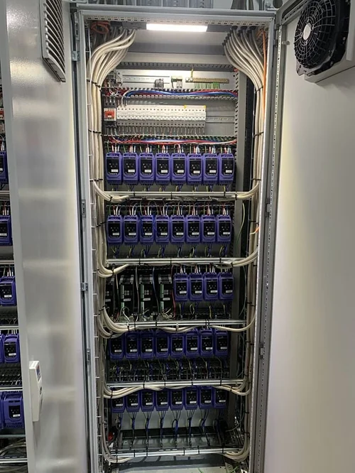 Electrical control panel containing circuit breakers, phase meters, and cooling fans