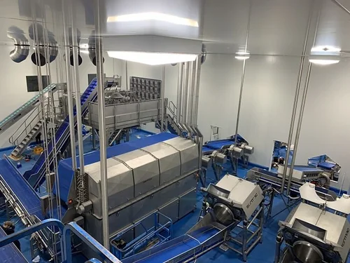 Industrial food processing facility with stainless steel equipment and conveyors